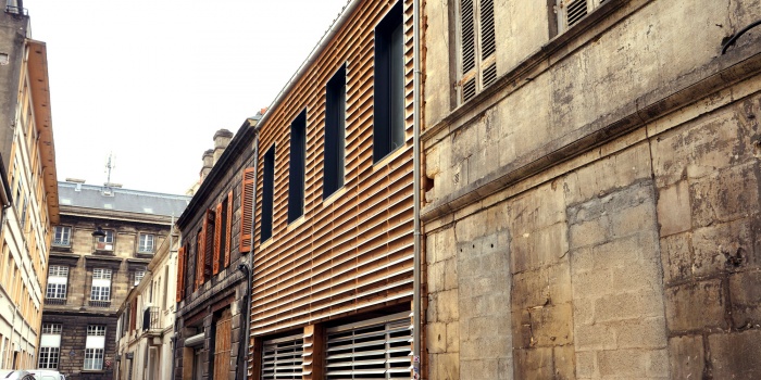 Habitat partagé à Bordeaux : Une façade en bois dans une rue en pierre